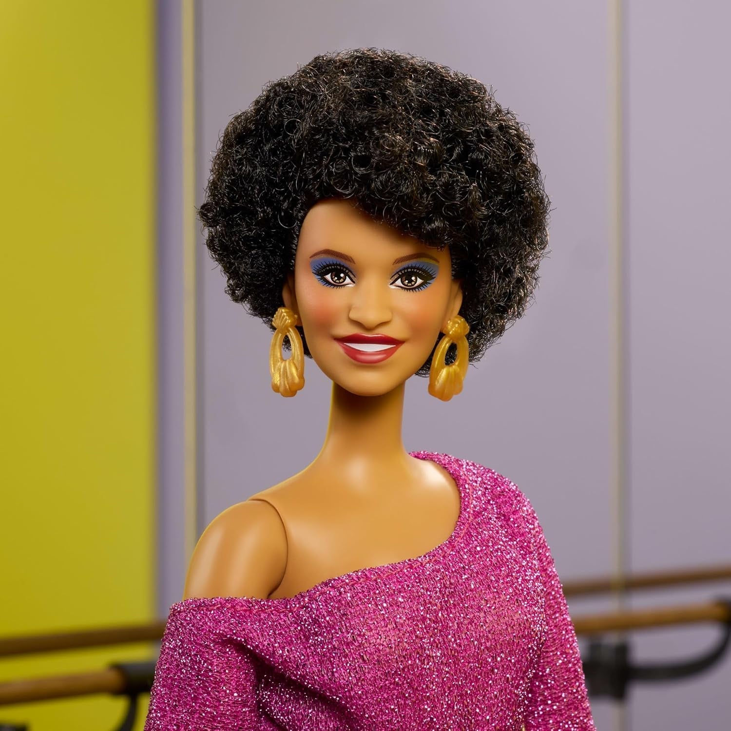 Păpușa Barbie Signature, Colecția Debbie Allen Tribute, cu bluză cu umeri goi, curea aurie și pantaloni mov cu franjuri și jambiere, JBJ24