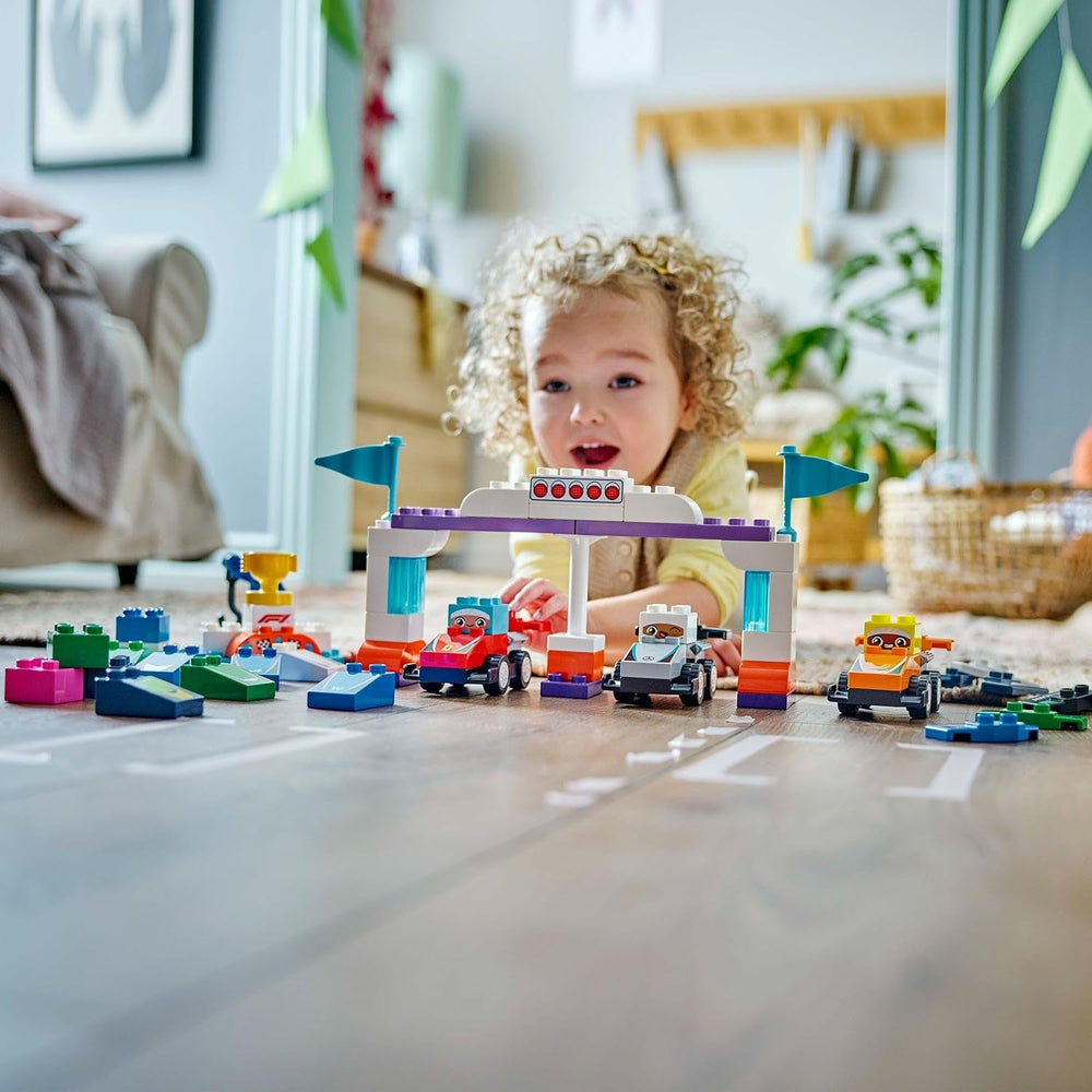 LEGO DUPLO Town F1 Team Rennautos mit Rennfahrern - Montessori Spielzeug für Mädchen & Jungen - Lernspielzeug für Kinder ab 2 Jahren - 10 Spielzeug Autos mit Kran, Startlichtern, Siegerpodest - 10445